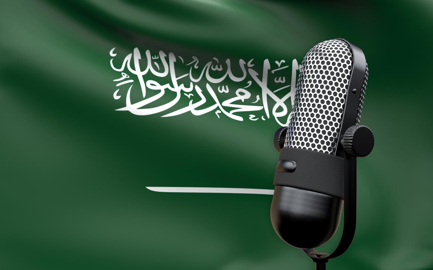 Microphone in front of the Saudi Arabia flag symbolising podcasting, expat life in Saudi Arabia, and cultural understanding.