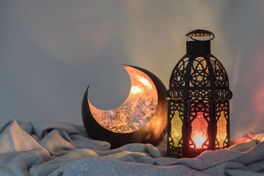 A crescent moon decoration and a traditional Ramadan lantern, iconic symbols used in Saudi Arabia to celebrate Ramadan with festive decor.