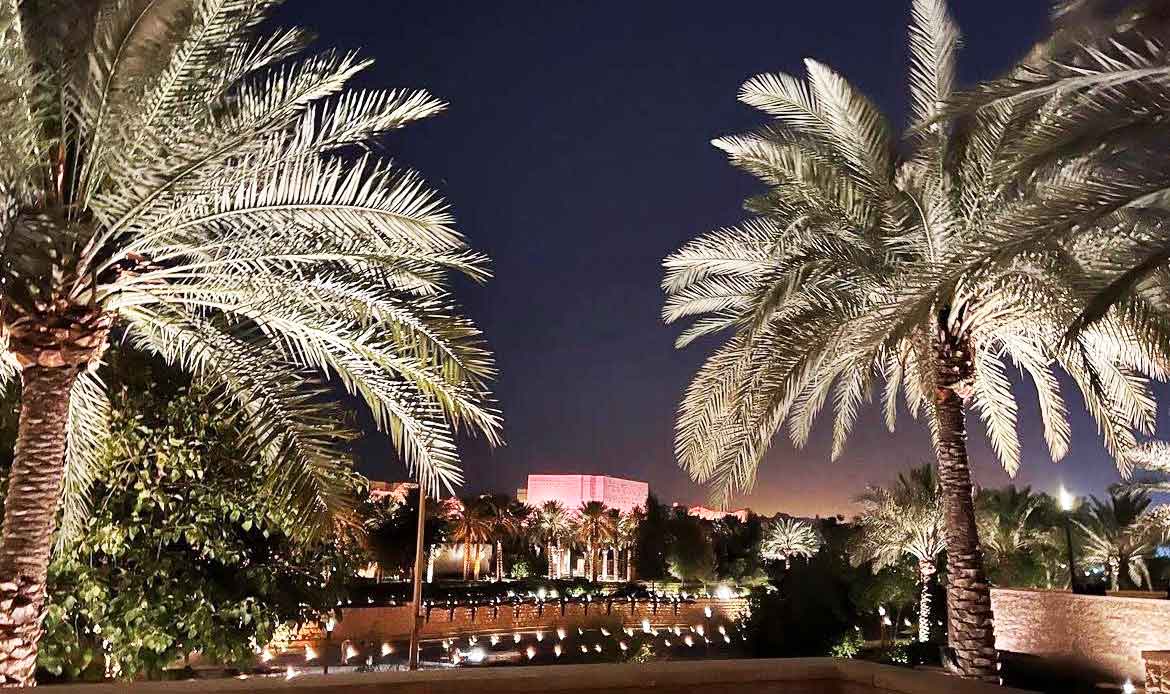 Night view of palm trees and architecture in Riyadh, highlighting the blend of Saudi heritage and modern design.