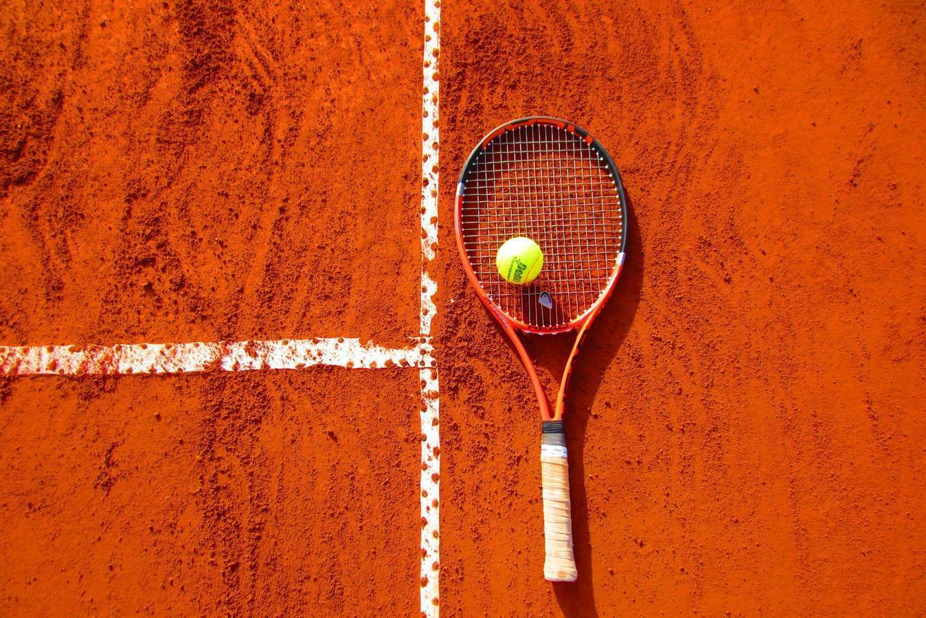 A tennis court with a racket, symbolizing Saudi Arabia's journey of overcoming obstacles on its path to development and progress.