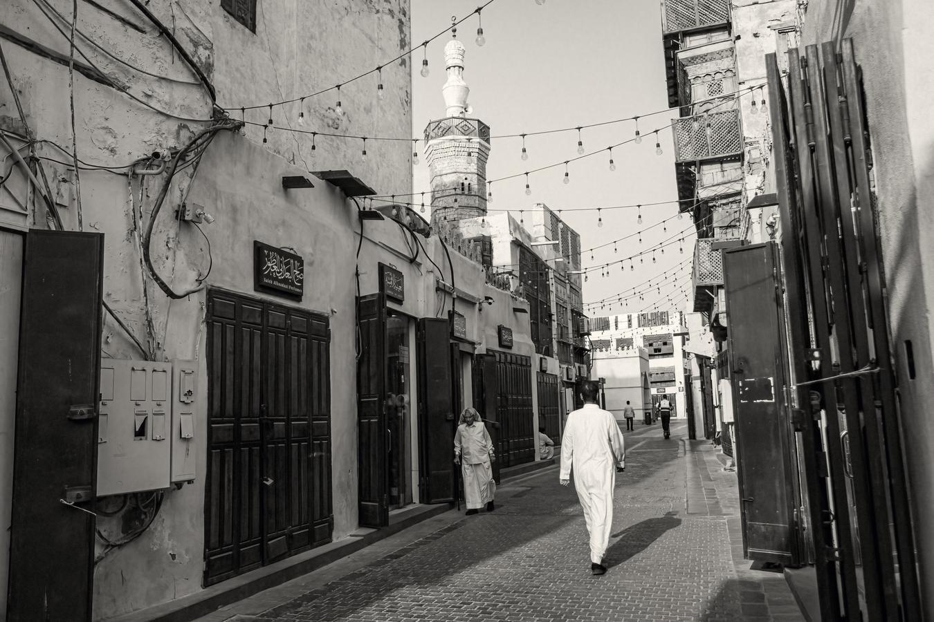 Historic street in Saudi Arabia with traditional buildings, Arabic signage, and people walking, reflecting cultural heritage and societal transformation. (Source: Shutterstock)