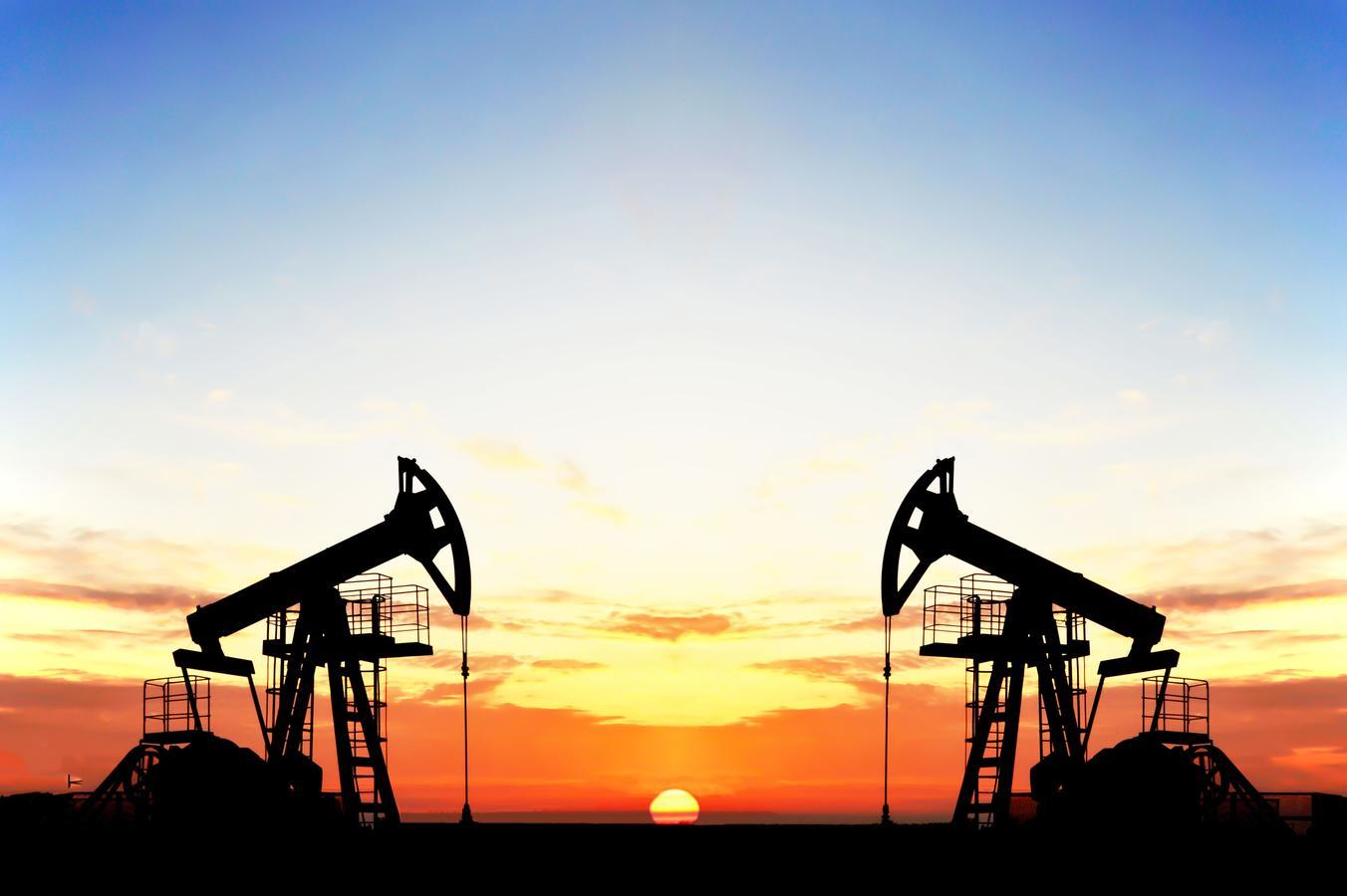 Silhouette of oil pump jacks at sunset symbolizing Saudi Arabia’s economic transformation and energy transition toward a post-oil, data-driven future.