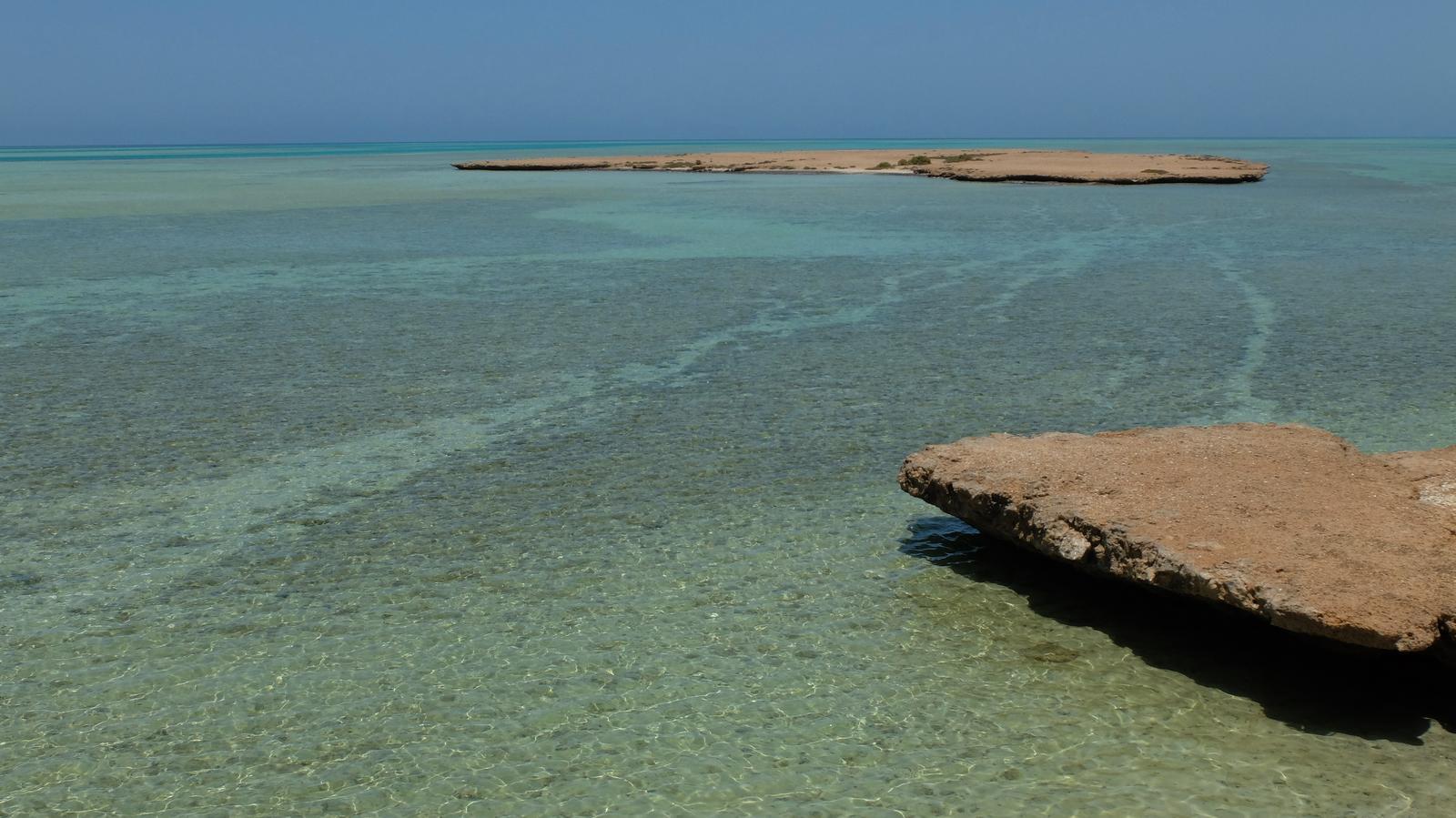 Shallow turquoise waters and rocky outcrops at Umluj Beach on Saudi Arabia’s Red Sea coast, known for its clear waters and untouched landscapes.