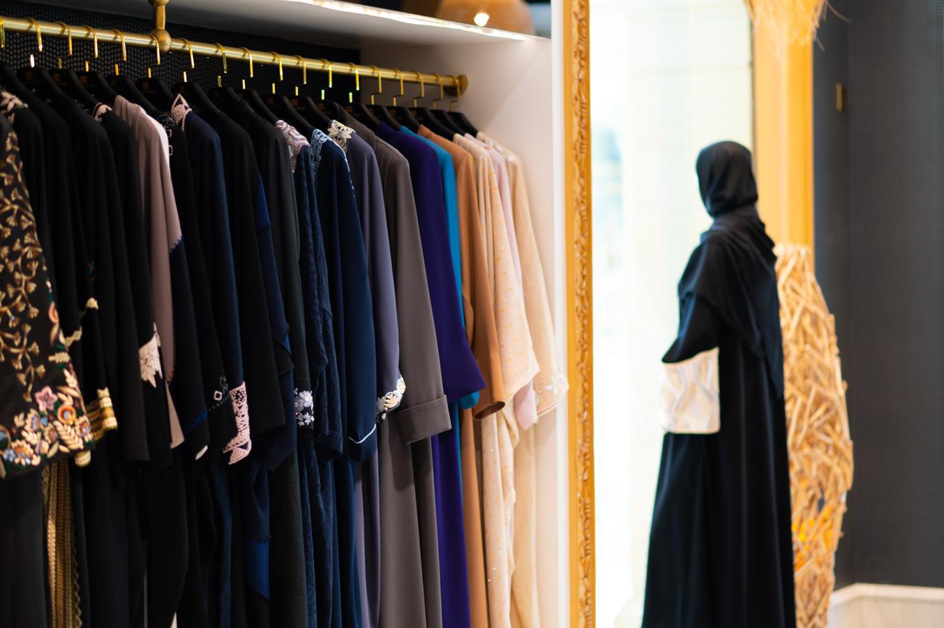 A Saudi woman shops for abayas at a clothing store in Jeddah. While wearing the abaya is no longer legally required, many women in Saudi Arabia continue to choose it in various styles and colors as part of evolving modest fashion norms.