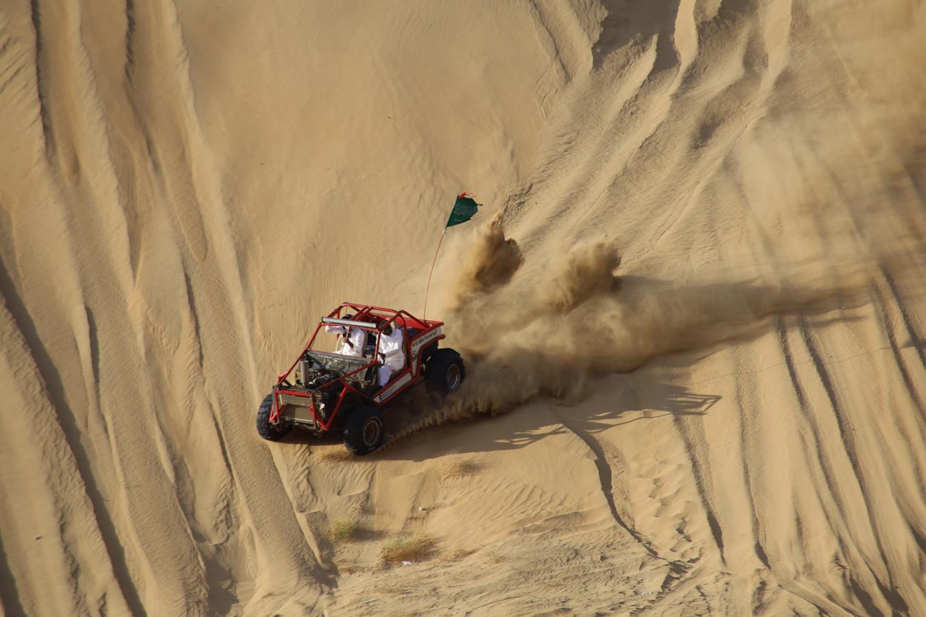 Off-road buggy carving through desert dunes, trailing sand and dust — a visual echo of Saudi Arabia’s enduring fascination with cars, speed, and open space.