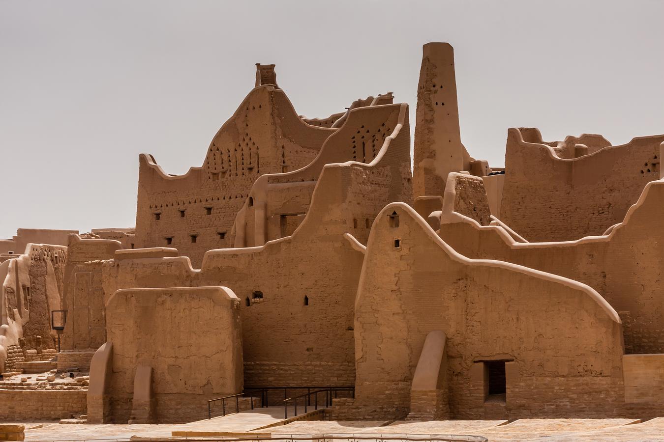 A view of Salwa Palace at the At-Turaif UNESCO World Heritage site in Diriyah, Saudi Arabia. The restored mudbrick architecture stands beneath a pale sky, representing the country’s efforts to document and preserve its pre-modern history.