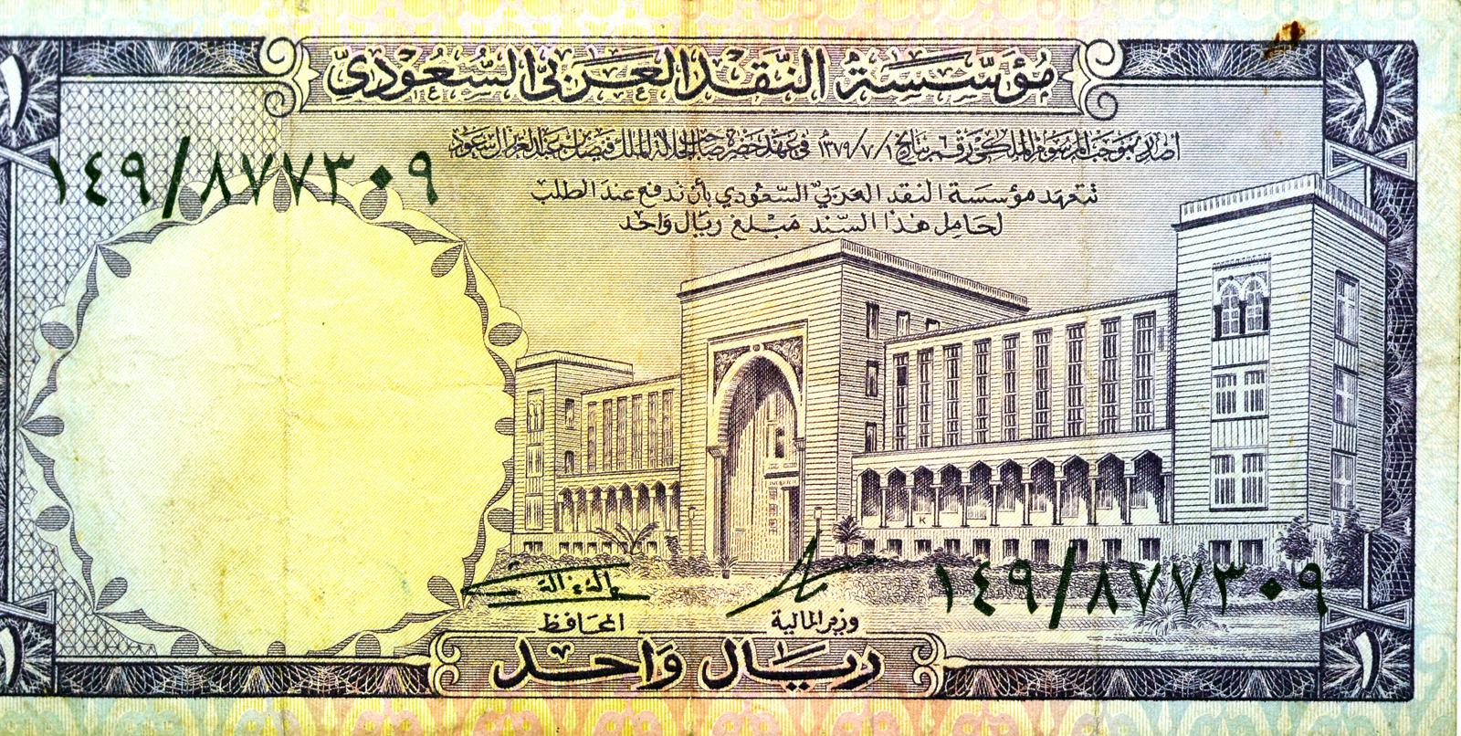 An old Saudi Arabian one-riyal banknote displaying Arabic text, an intricate border, and a detailed architectural illustration of a government building. The banknote includes handwritten serial numbers and official signatures.