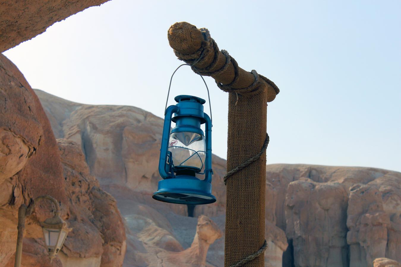 Traditional kerosene heritage lamp in Saudi Arabia desert, symbolizing culture and travel.