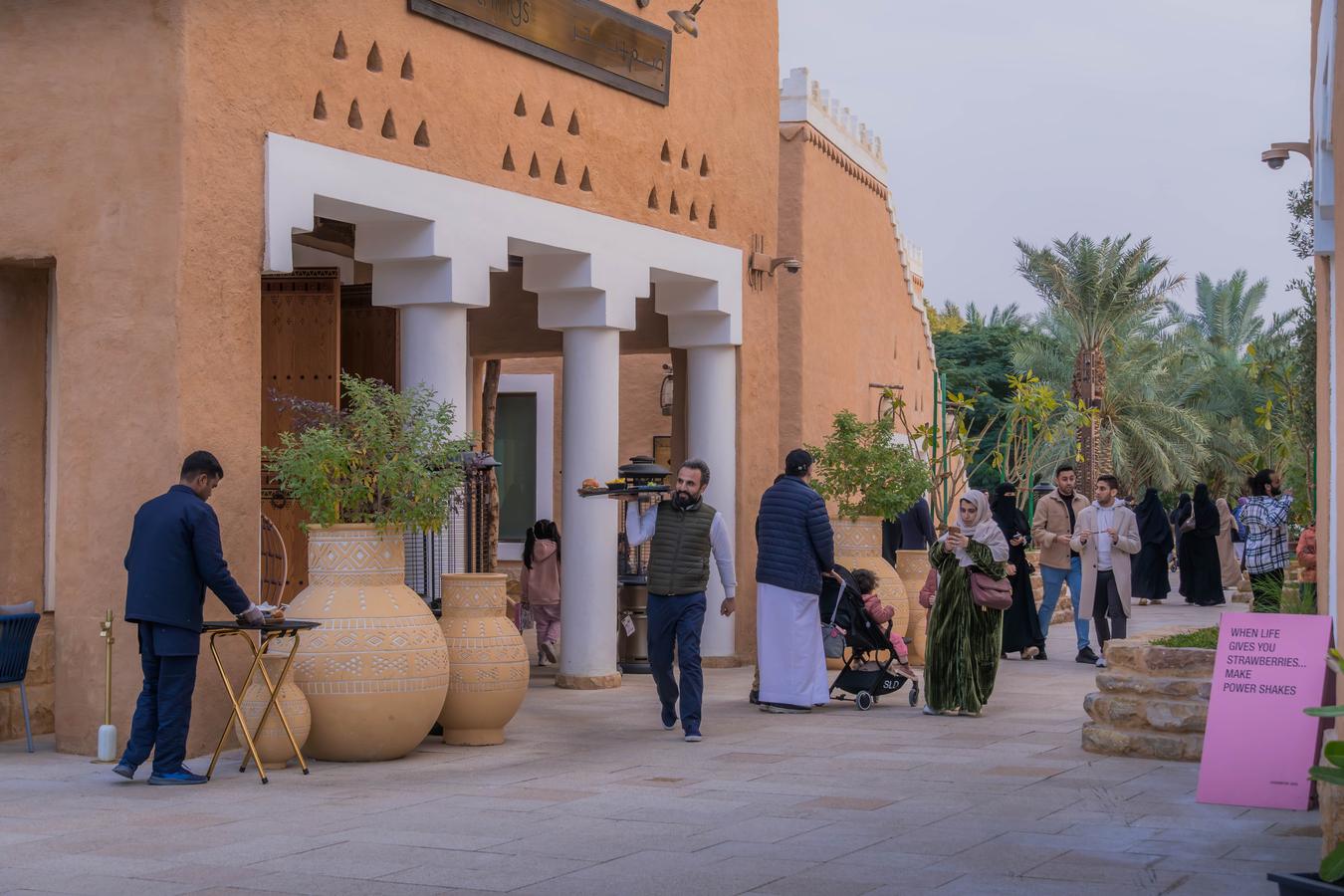 Street scene in Saudi Arabia showing young people walking, socialising, and engaging in public spaces, illustrating modern lifestyles, urban culture, and social change in Saudi society.